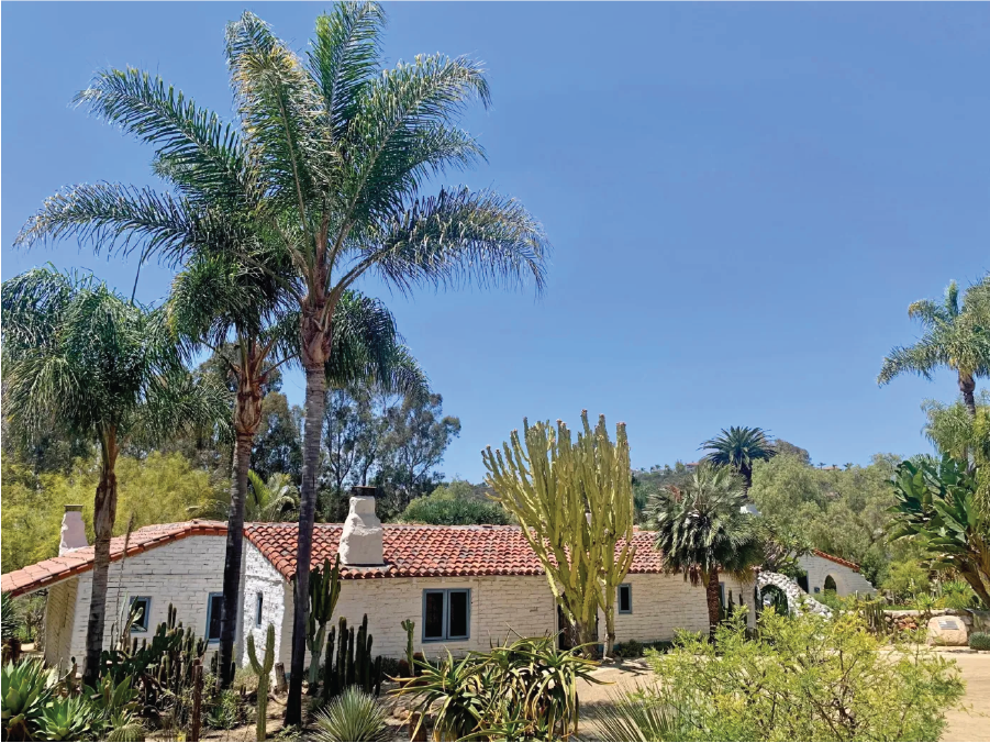 Photo of The main adobe structure at Leo Carrillo Ranch Historic Park. Restored adobe buildings and surrounding plantings show how the site has been preserved.